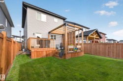 Expansive backyard featuring a manicured lawn, full wood fencing, and a multi-level wood deck - 
