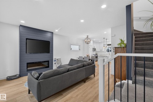 Open-concept living space with a shiplap feature wall and built-in fireplace - 548 Kleins Crescent, Leduc, AB 