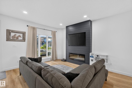 Living area featuring wide plank wood-finish flooring, recessed lighting, and a window with natural light - 548 Kleins Crescent, Leduc, AB 
