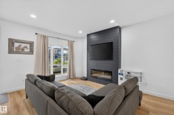 Living area featuring wide plank wood-finish flooring, recessed lighting, and a window with natural light - 