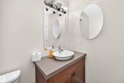 Vanity with a vessel sink, dark brown cabinetry, and a dark countertop - 