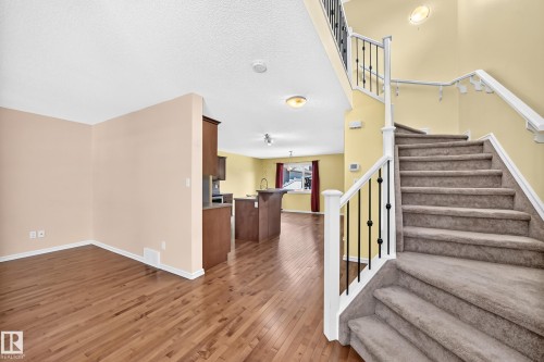 Carpeted staircase with white newel posts and black iron balusters - 211 59 Street, Edmonton, AB 