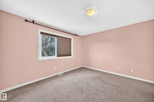 Room featuring neutral pink walls, gray carpet, and white trim - 211 59 Street, Edmonton, AB 