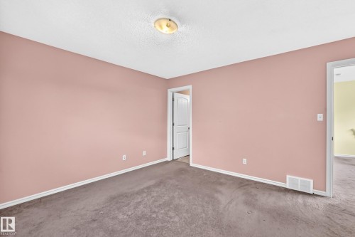 Room with pink-painted walls, textured white ceiling, and a ceiling-mounted light fixture - 211 59 Street, Edmonton, AB 