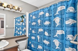 Bathroom featuring a shower curtain rod, a vanity mirror, a wall-mounted light fixture with five sconces, a built-in grab bar, and a single-handle faucet - 