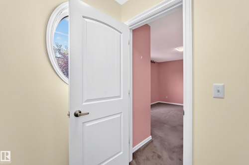 Arch-panel interior door with brushed nickel hardware, set within a neutral-toned hallway - 211 59 Street, Edmonton, AB 