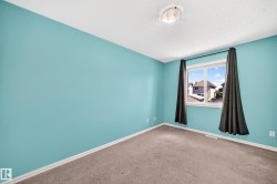 Room featuring a window with white trim, light blue walls, and a textured ceiling - 