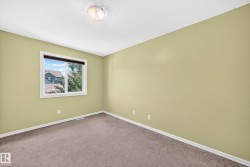 Neutral wall paint, carpet flooring, a window with exterior views, white trim, and a ceiling-mounted light fixture - 