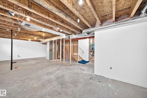 Unfinished basement space featuring exposed wood joists and subflooring, concrete flooring, and partial framing - 211 59 Street, Edmonton, AB 