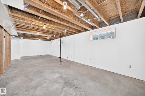 Expansive unfinished basement featuring concrete flooring and white-painted walls - 211 59 Street, Edmonton, AB 