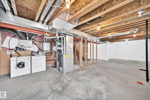 Unfinished basement with concrete flooring and exposed ceiling joists - 211 59 Street, Edmonton, AB 