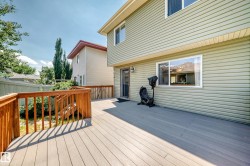 Expansive composite deck featuring a wooden railing system and stairs - 