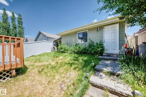 Exterior featuring horizontal siding, a white entry door, and a single-pane window - 211 59 Street, Edmonton, AB 