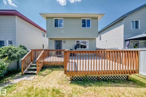 Expansive wood deck with stairs leading to the yard, featuring a lattice skirt and wood railings - 211 59 Street, Edmonton, AB 