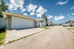 Detached garage with horizontal siding and a dual garage door - 