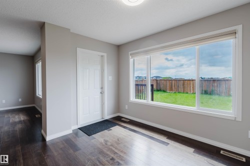 Expansive window overlooking a fenced backyard with green space - 16627 18 Avenue, Edmonton, AB 