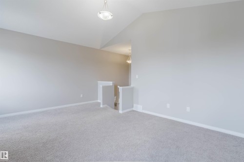 Open concept room featuring vaulted ceilings, light gray carpeting, and neutral wall tones - 16627 18 Avenue, Edmonton, AB 