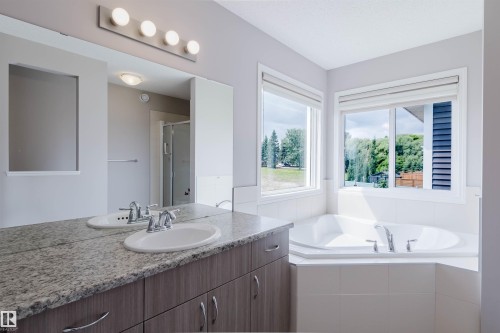 Soaking tub with white tile surround and dual windows - 16627 18 Avenue, Edmonton, AB 