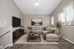 Living room featuring vaulted ceilings, neutral wall tones, multiple windows with blinds, and a built-in stair railing - 