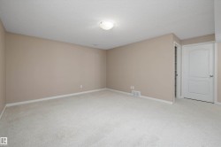 Spacious room featuring neutral carpeting and light beige wall tones - 