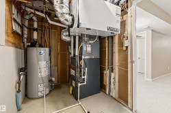 Utility room featuring a water heater, furnace, and ventilation system - 