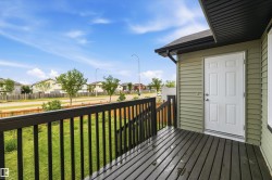 Exterior deck with dark wood-finish flooring and black railings - 