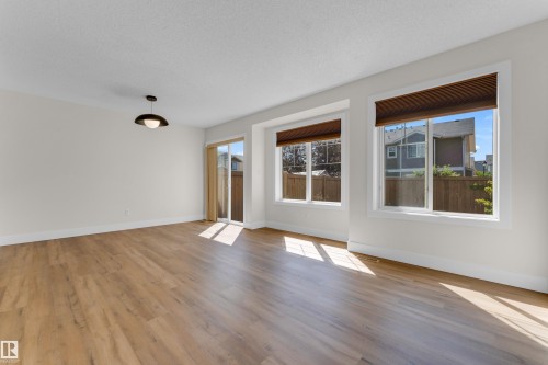 Spacious room with wood-finish flooring and neutral wall tones - 64 14208 36 Street, Edmonton, AB 