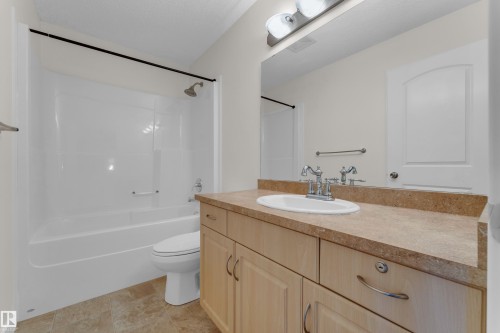 Bathroom vanity with an integrated basin, chrome faucet, and expansive mirror - 64 14208 36 Street, Edmonton, AB 