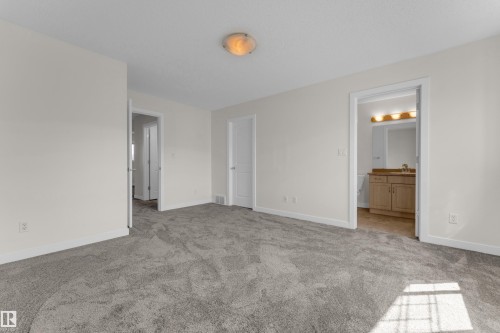 Spacious room featuring light gray carpet flooring and white baseboards - 64 14208 36 Street, Edmonton, AB 
