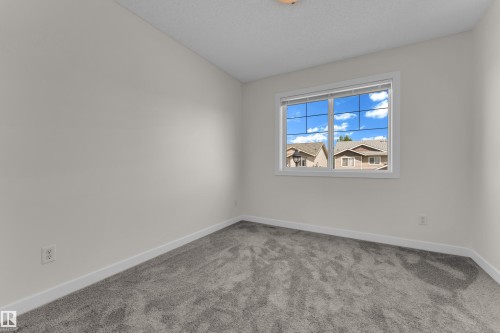 Bright room featuring a window with white trim, neutral wall paint, and gray carpet flooring - 64 14208 36 Street, Edmonton, AB 
