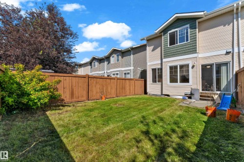 Private fenced backyard featuring a grassy lawn - 64 14208 36 Street, Edmonton, AB 