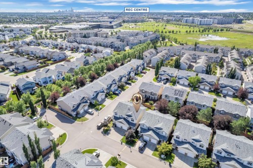 Aerial perspective highlighting a residential neighborhood with detached homes featuring asphalt shingle roofs and integrated garages - 64 14208 36 Street, Edmonton, AB 