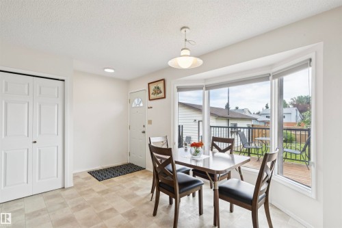 Bright dining area with large bay windows, recessed lighting, and a neutral tile floor - 9315 168 Avenue Nw, Edmonton, AB 
