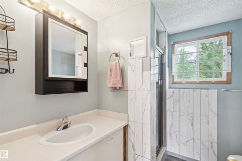 Bathroom vanity featuring an oval sink, single-handle faucet, and built-in medicine cabinet with integrated lighting - 9315 168 Avenue Nw, Edmonton, AB 