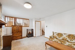 Carpeted living space with white walls and a ceiling-mounted light fixture - 