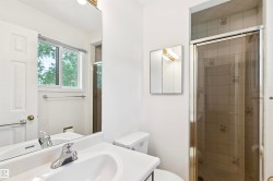 Bathroom featuring a single vanity with an integrated sink, chrome faucet, wall-mounted mirror, and a medicine cabinet with a vanity light - 