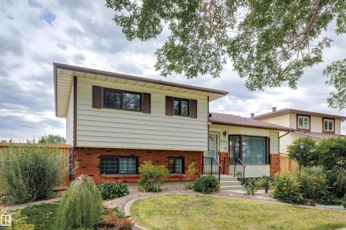 Split-level residence featuring a brick and siding exterior, front yard landscaping, and a bay window - 9315 168 Avenue Nw, Edmonton, AB 