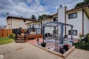 Outdoor entertaining area featuring a multi-level deck with black railings, a paved patio, and a pergola structure - 9315 168 Avenue Nw, Edmonton, AB 