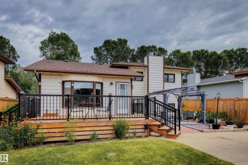 Rear exterior with a multi-level wood-finish deck featuring black metal railings - 9315 168 Avenue Nw, Edmonton, AB 