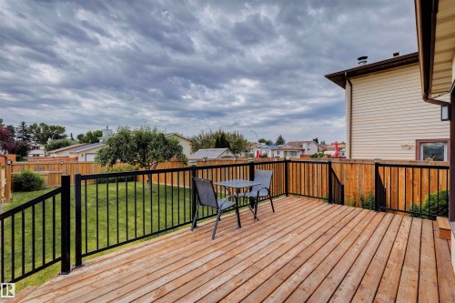 Spacious outdoor wood-finish deck with black metal railings - 9315 168 Avenue Nw, Edmonton, AB 