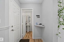 Entryway featuring light gray walls, white trim, and wood-finish flooring - 