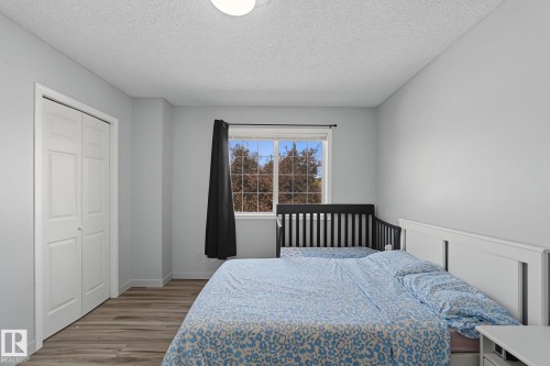 Bedroom featuring light gray walls and wood-finish flooring - 5 14603 Miller Boulevard, Edmonton, AB 