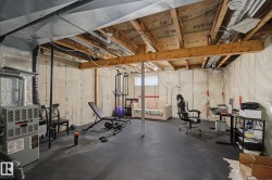 Unfinished basement featuring concrete walls and exposed wood ceiling joists - 