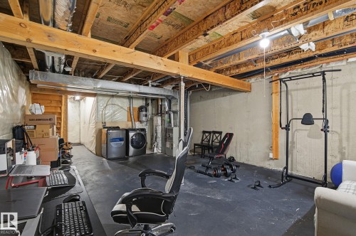 Unfinished basement with exposed ceiling joists and concrete walls - 5 14603 Miller Boulevard, Edmonton, AB 