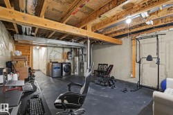 Unfinished basement with exposed ceiling joists and concrete walls - 