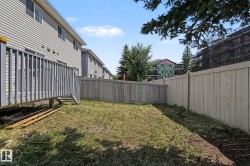 Backyard featuring a wooden privacy fence, a raised deck with gray railings, and a siding exterior - 