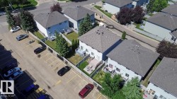 Aerial perspective showcasing multiple two-story properties with fenced backyards - 