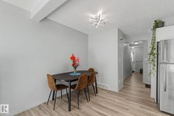 Dining area featuring light wood-finish flooring, light grey walls, and a contemporary ceiling fixture - 