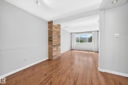 Hardwood flooring extends throughout this space featuring a decorative wood-panel accent wall - 