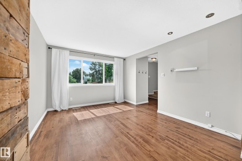 Bright living space featuring wood-finish flooring and a large window - 32 Mcleod Place, Edmonton, AB 